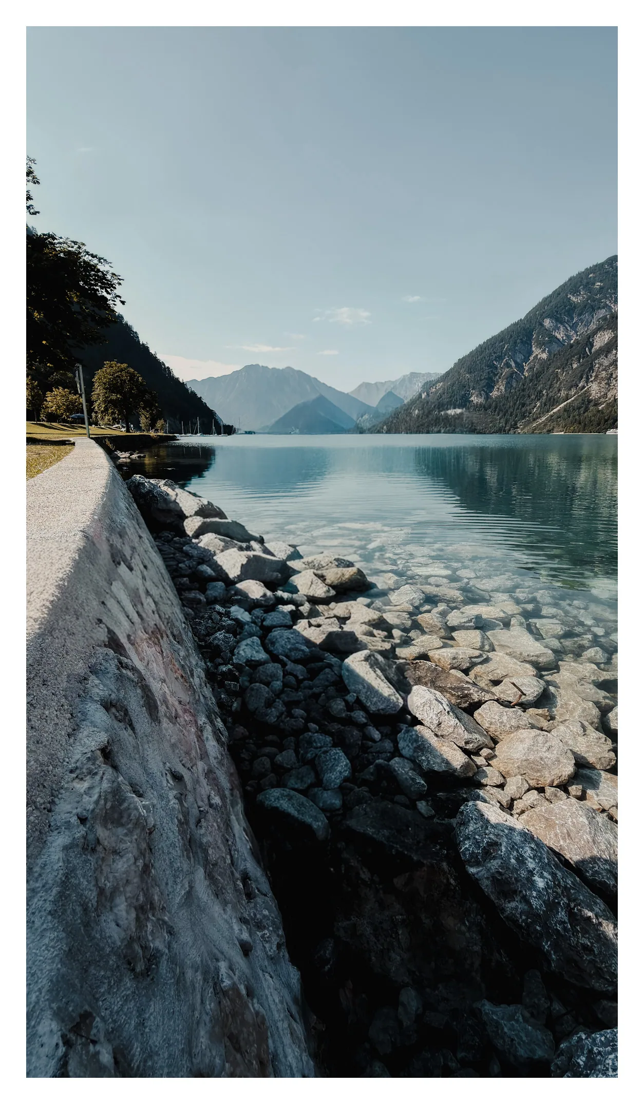 De heldere Achensee en de rotsachtige oever bij Pertisau